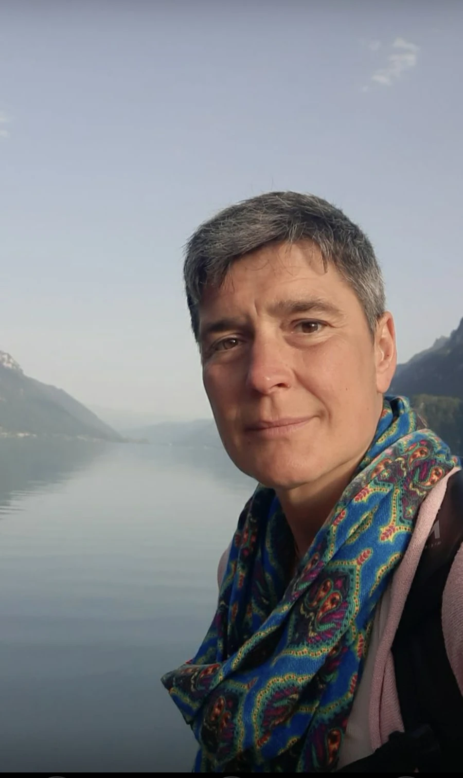 Portrait von Ryke vor einer Berg- und Seenlandschaft.